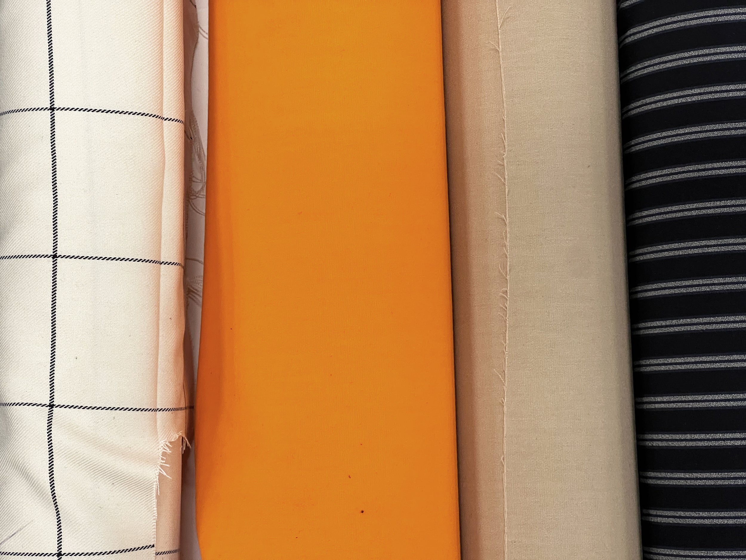several rolls of fabrics in different colors