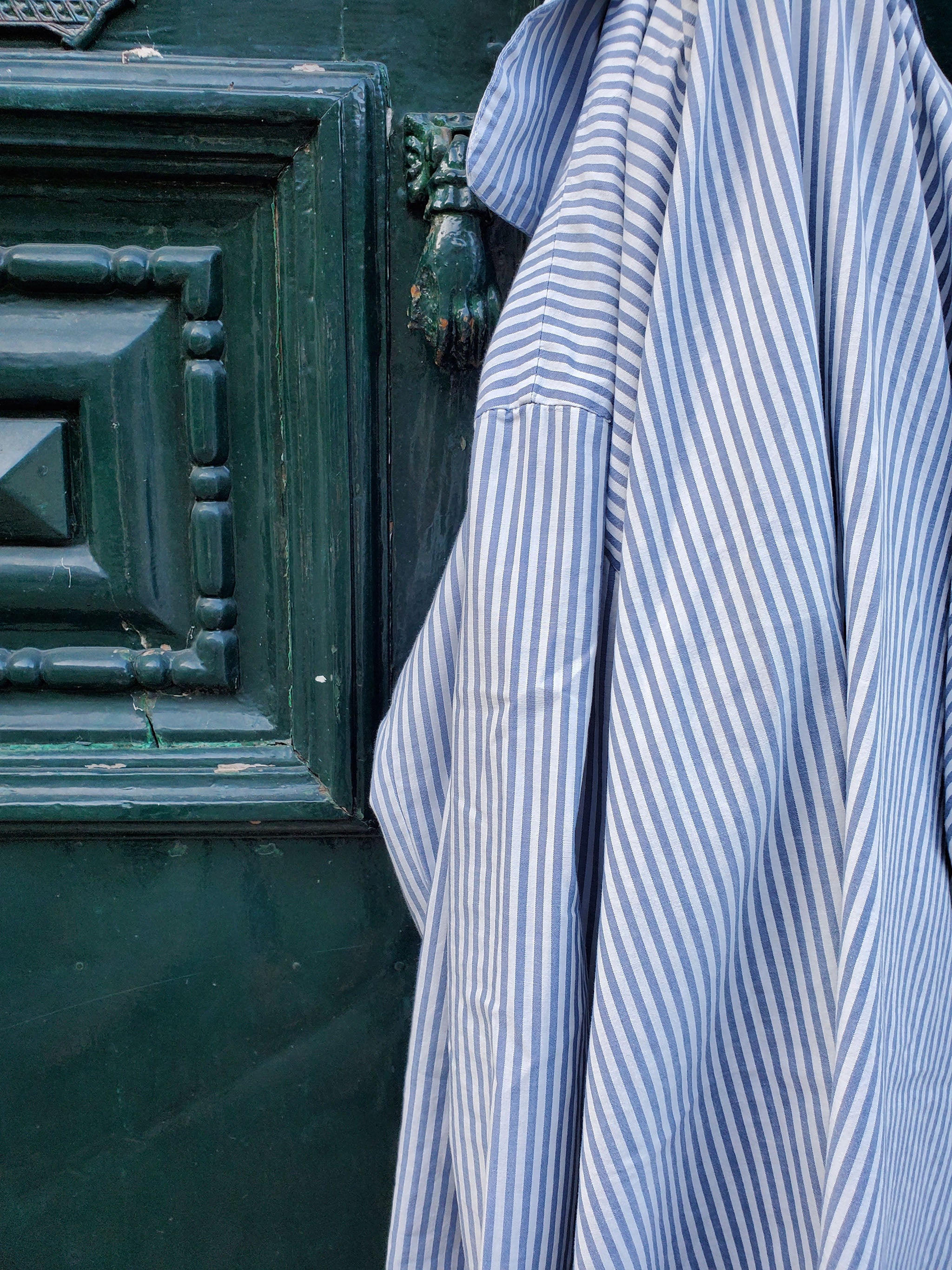 close up of striped pyjama shirt hanging at a door handle